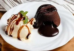 Petit gâteau com sorvete de creme e calda de chocolate